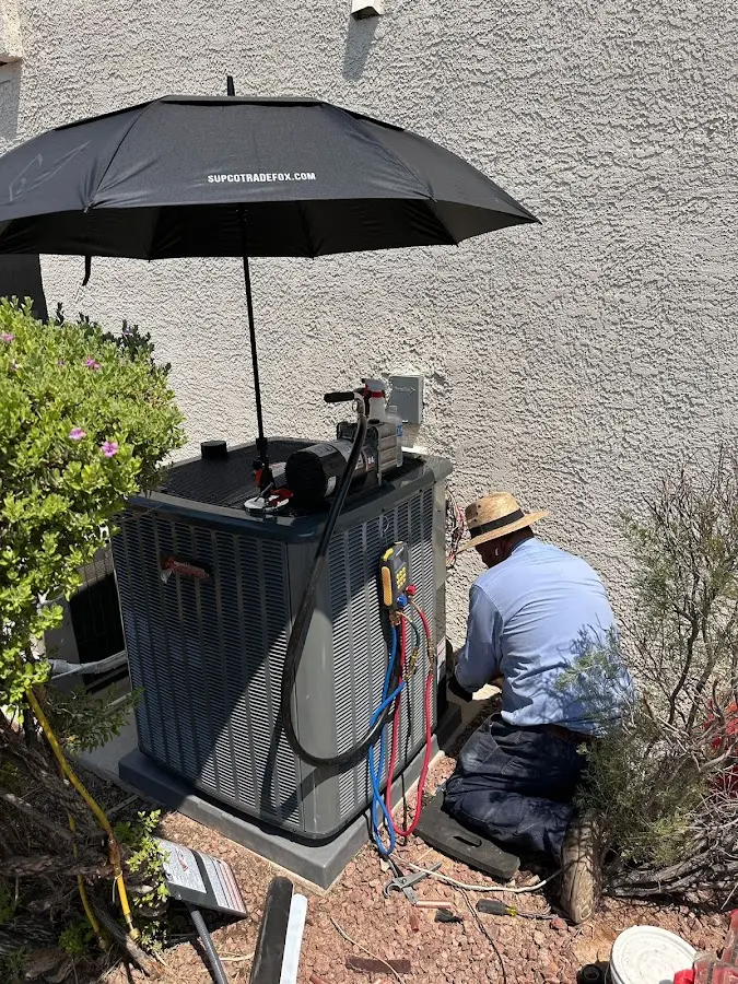 HVAC technician performing outdoor AC maintenance in Dumont